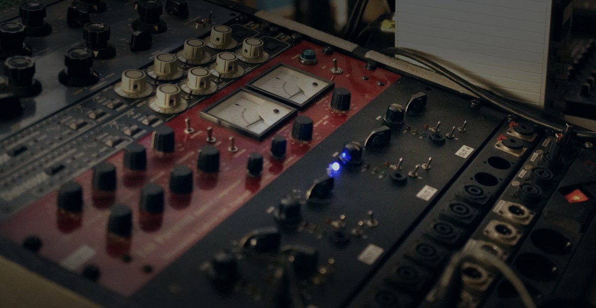 Analog mastering outboard gear with VU meters on a studio desk